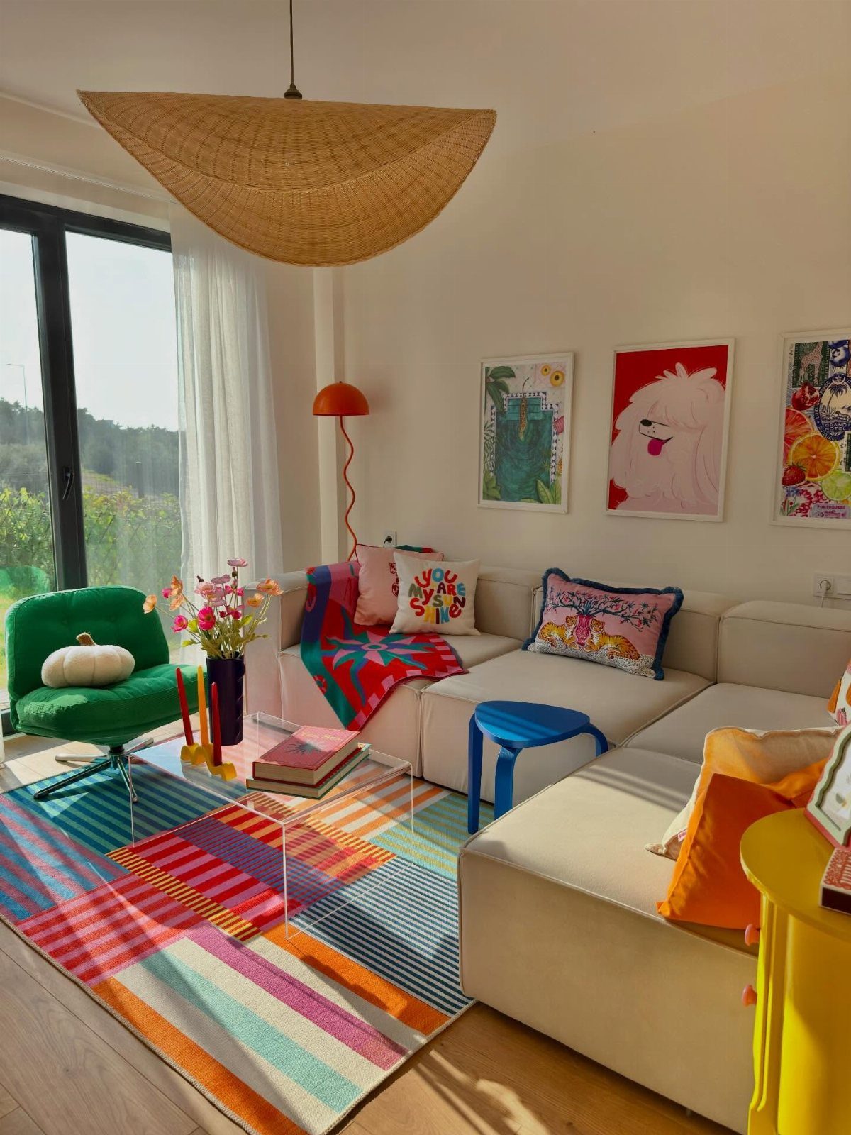 Colorful living room with a striped rug, white sofa, and vibrant wall art.