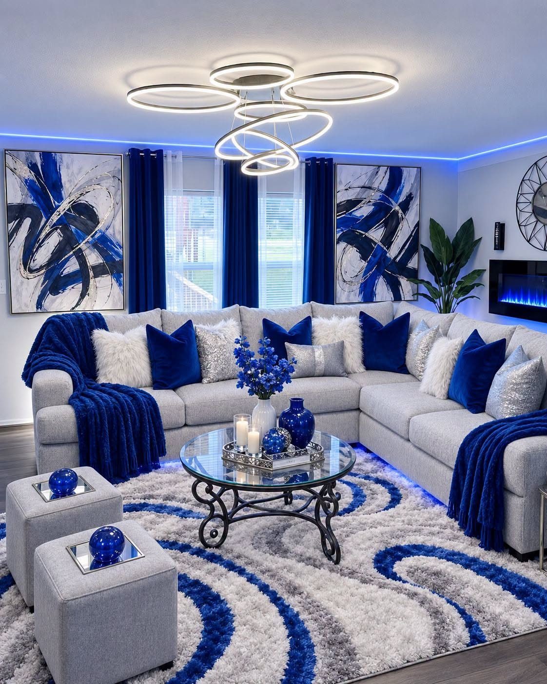 Abstract blue paintings hanging on a white wall above a grey sectional sofa.