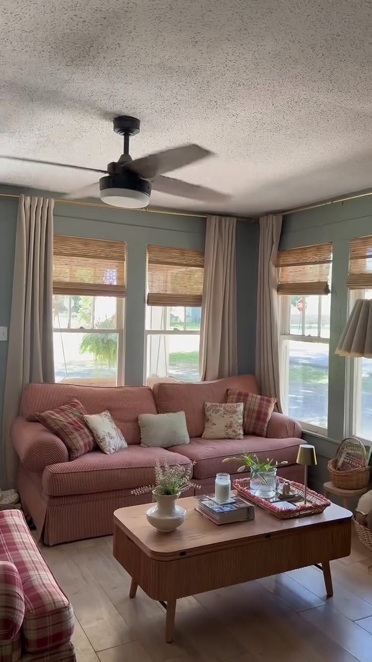 Woven wood shades and beige curtains on windows in a cozy living room.