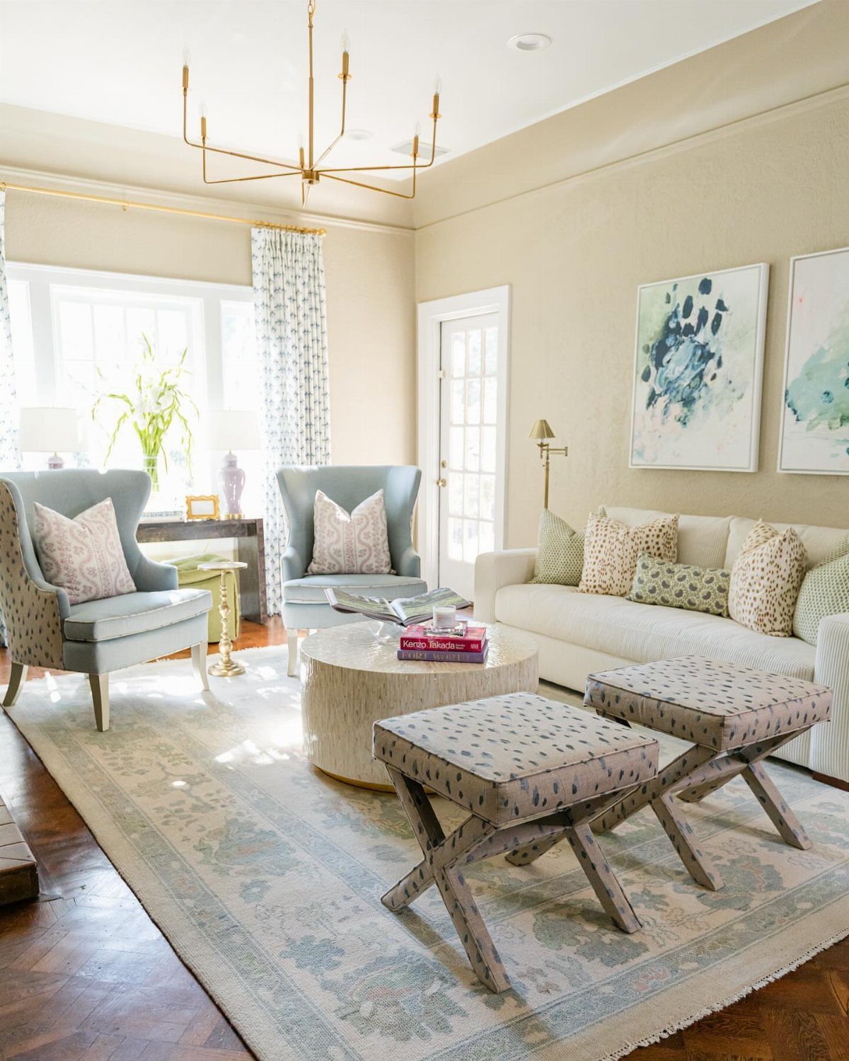 Bright living room with two light blue accent chairs and a white sofa.
