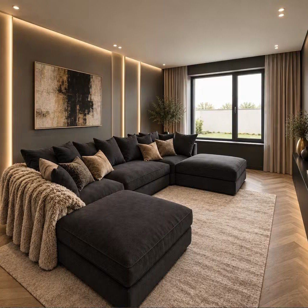 Black sectional sofa with beige pillows and throw on a light beige rug.