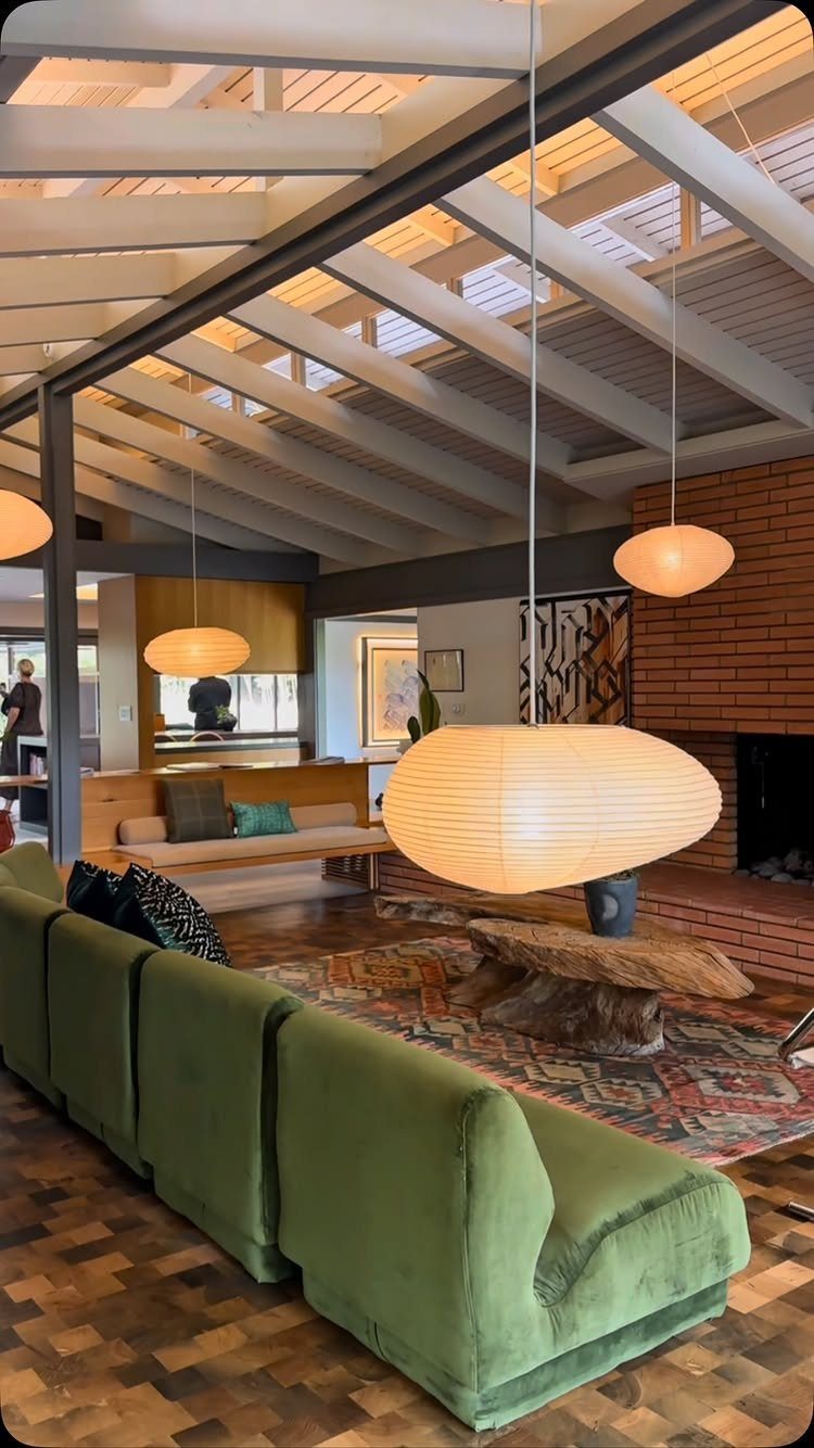 Green velvet sofa and rustic wood table in a midcentury modern living room.