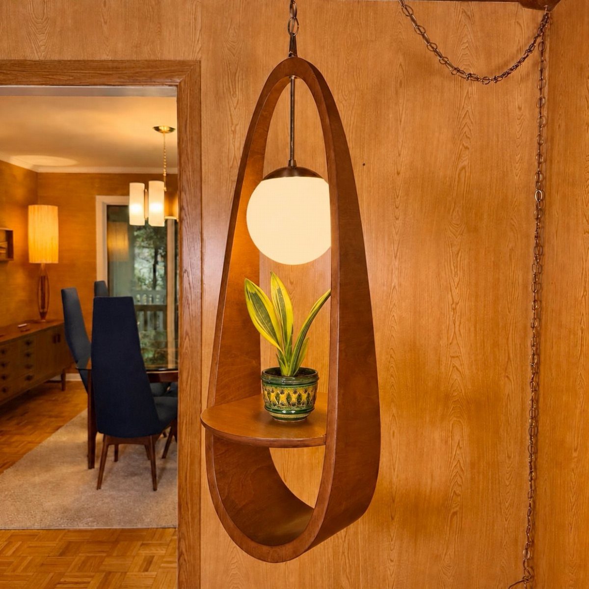Wooden oval wall pendant light with a white globe and a small plant.