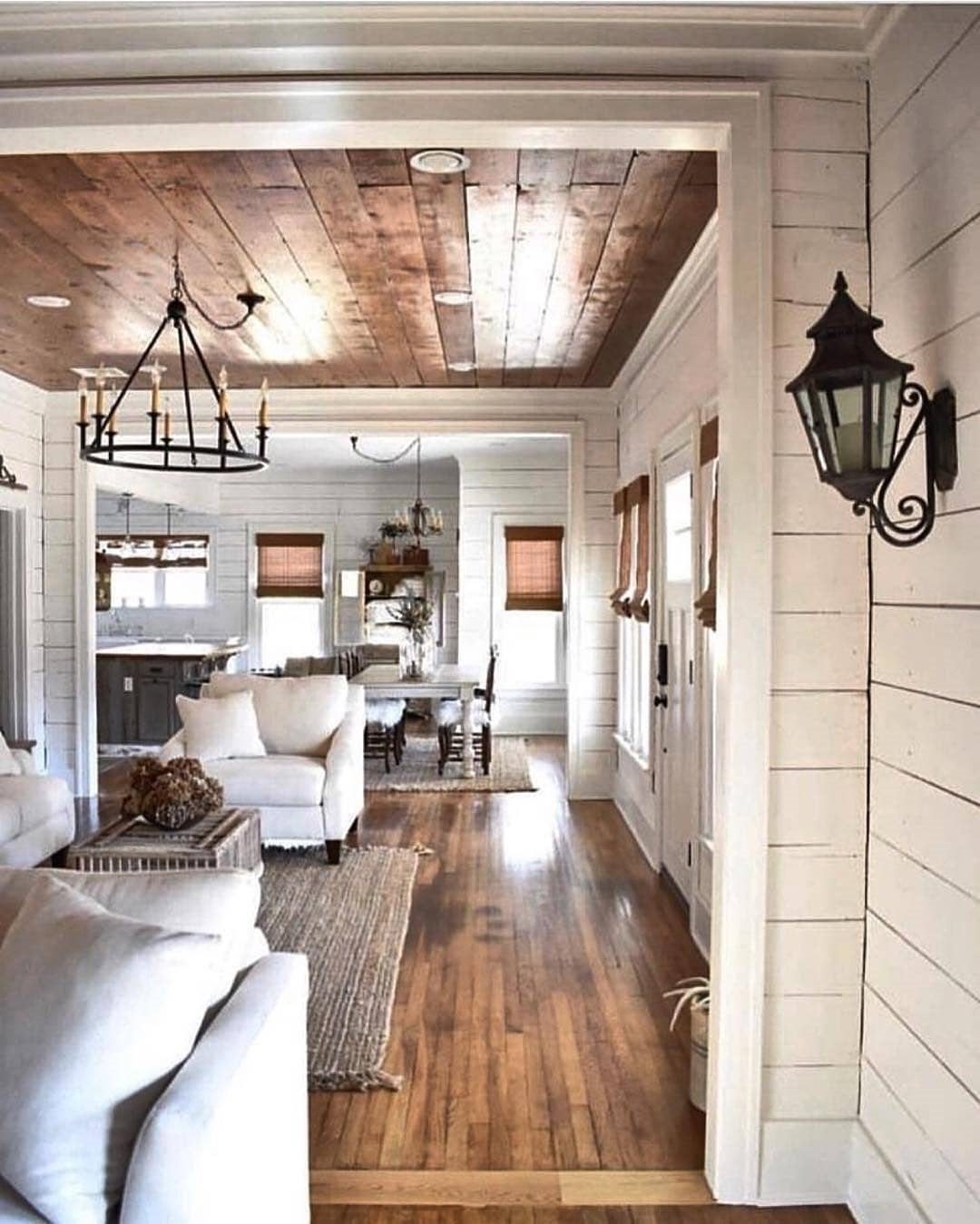 White shiplap walls in a modern farmhouse living room with wood plank ceilings.