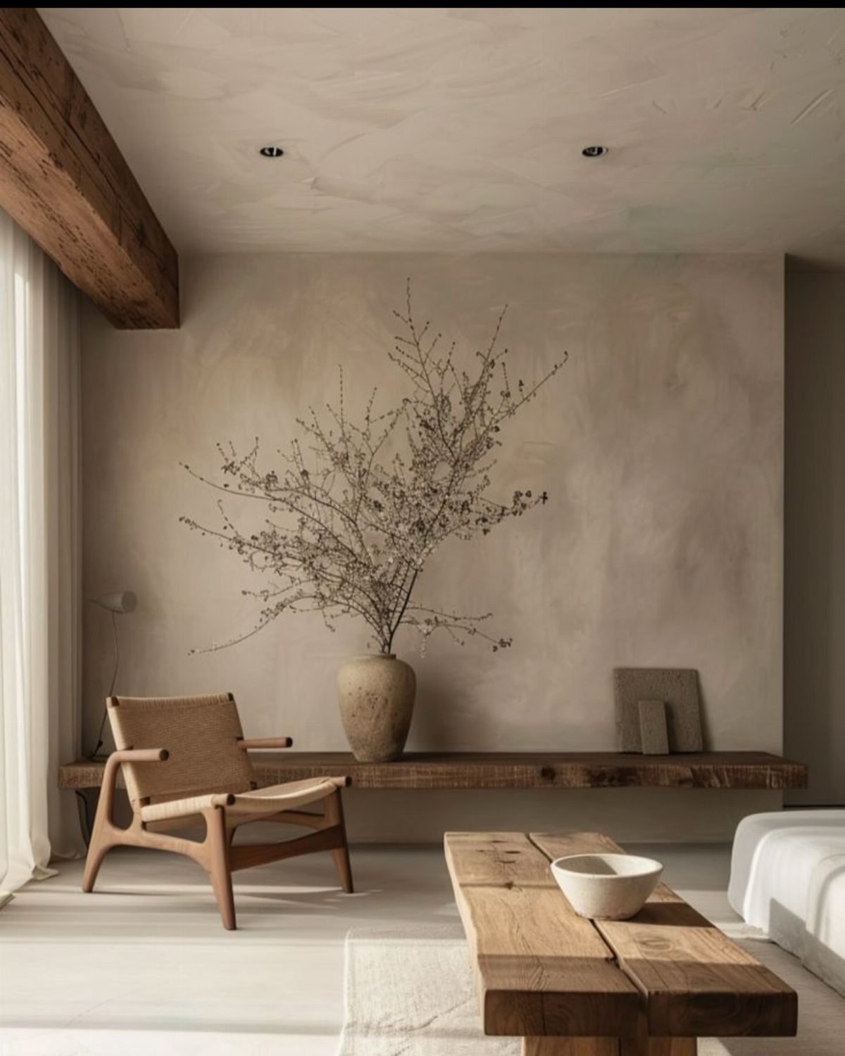 Textured beige plaster walls in a minimalist room with rustic wooden furniture.