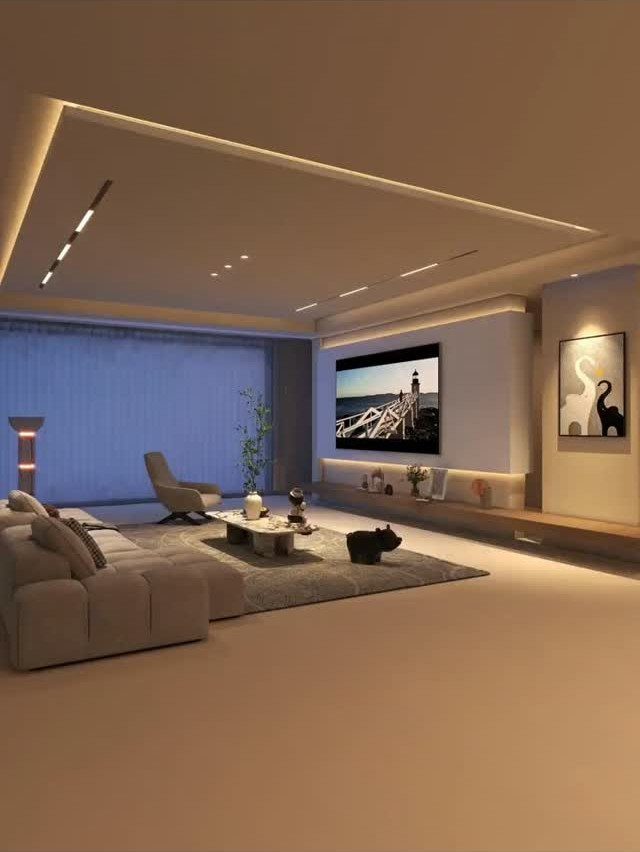 Modern living room with recessed ceiling lighting, beige sofa, and wall-mounted television.