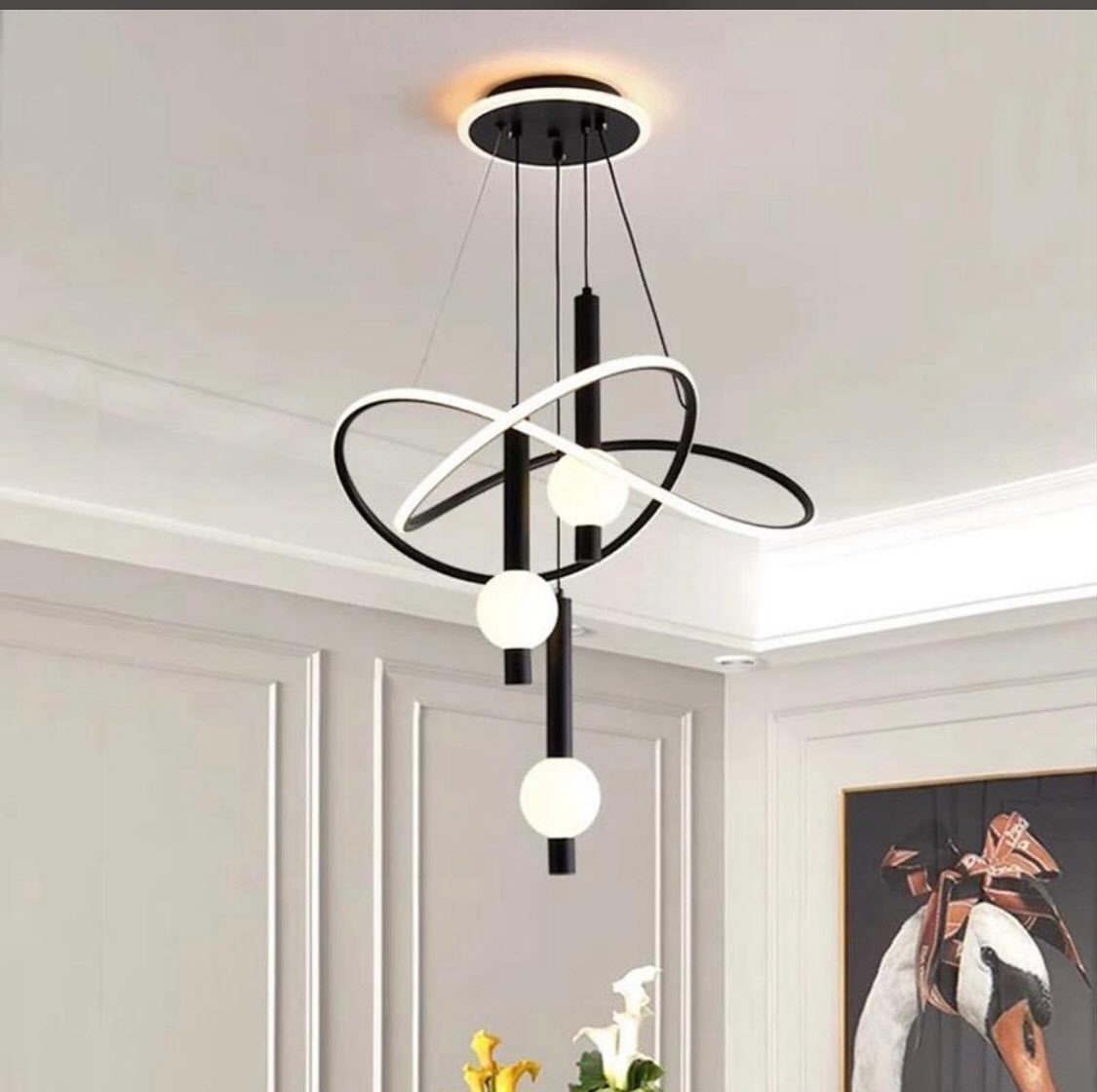 Modern black and white sculptural pendant light with glowing spheres and curved LED band.