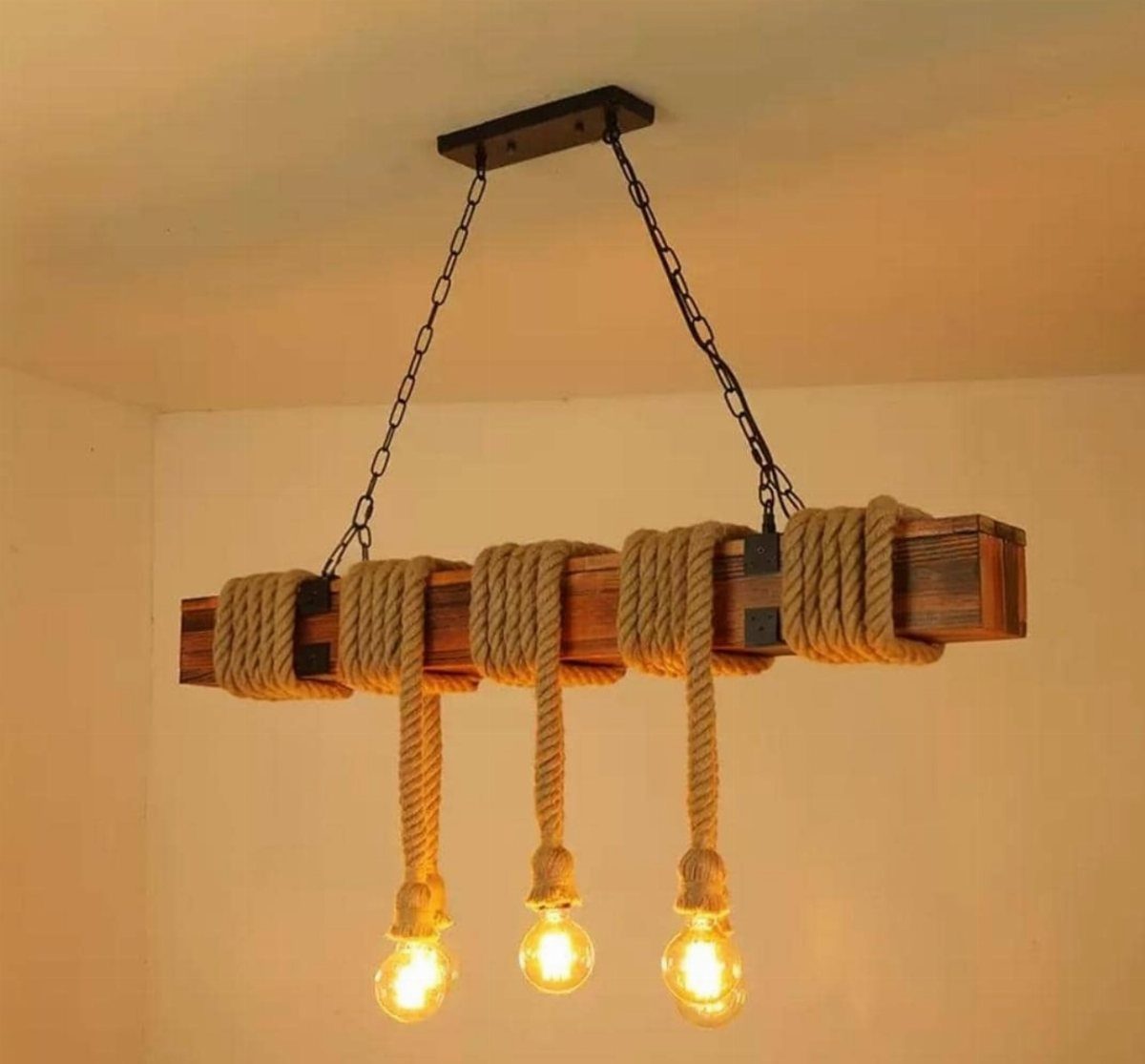 Rustic ceiling light with wooden beam, jute ropes, and three glowing Edison bulbs.