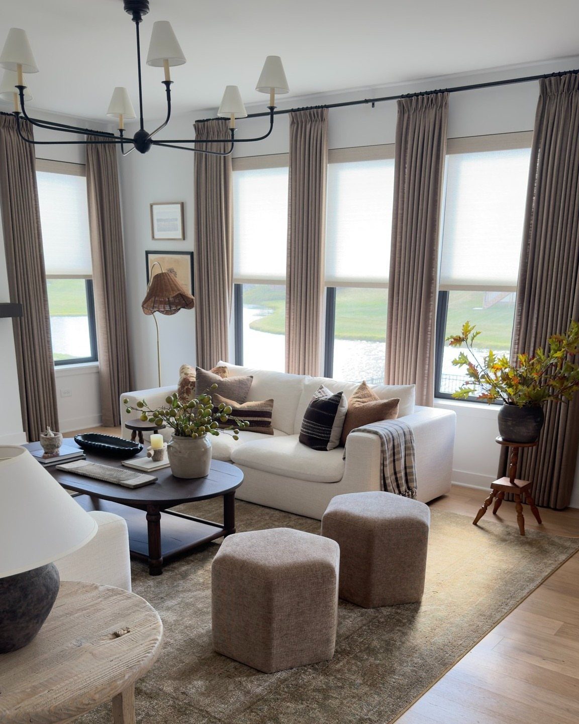 Neutral taupe curtains and white roller shades in a modern, bright living room.
