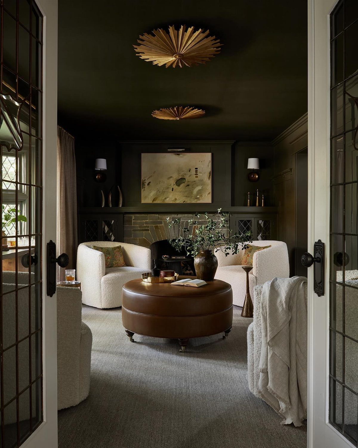Dark sitting room with a black ceiling and gold starburst light fixtures.