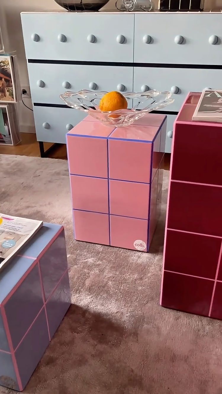 Colorful modular storage units in pink and magenta next to a blue dresser.