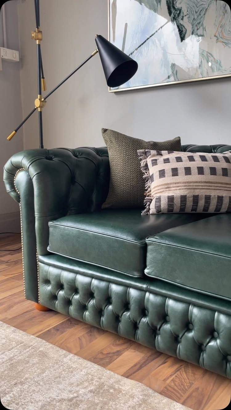 Dark green leather Chesterfield sofa with button tufting in a modern living room