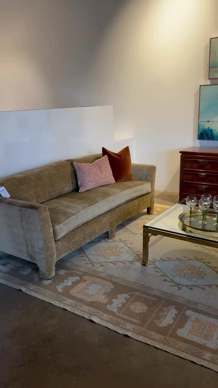 Tan velvet tuxedo sofa with square arms on a patterned rug in a living room