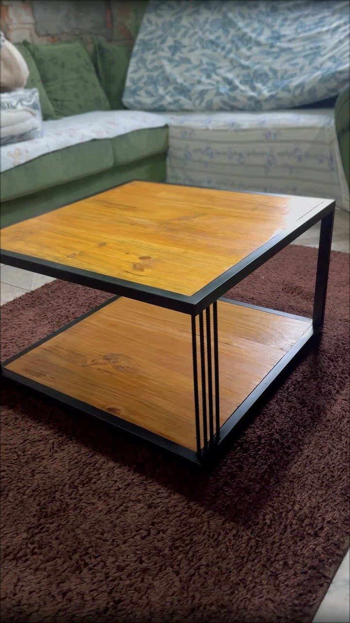 Two-tier wooden coffee table with black metal legs on a brown shag rug.