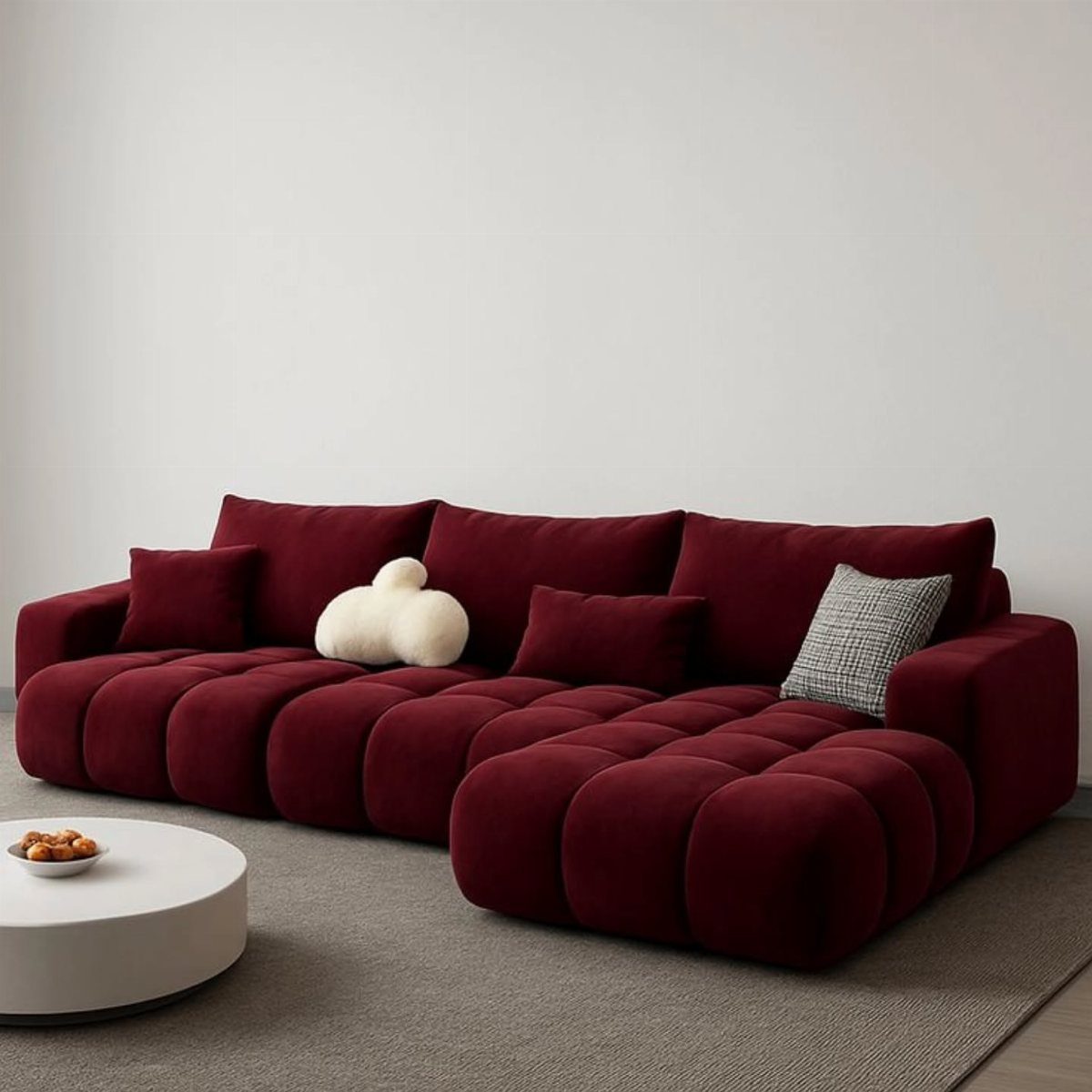 Deep red modular bubble sofa with throw pillows in a minimalist white room