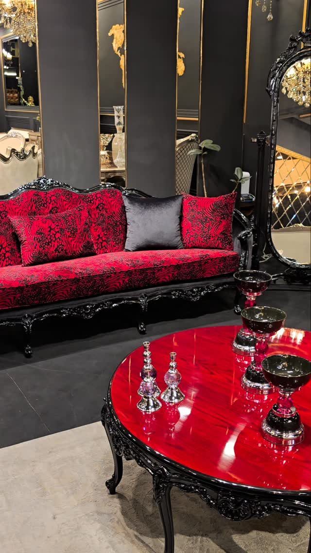 Ornate red damask sofa and matching red glossy coffee table in dark room