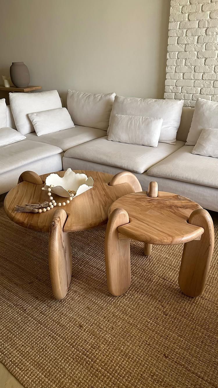 Brown jute rug under organic wooden coffee tables and a white modular sofa