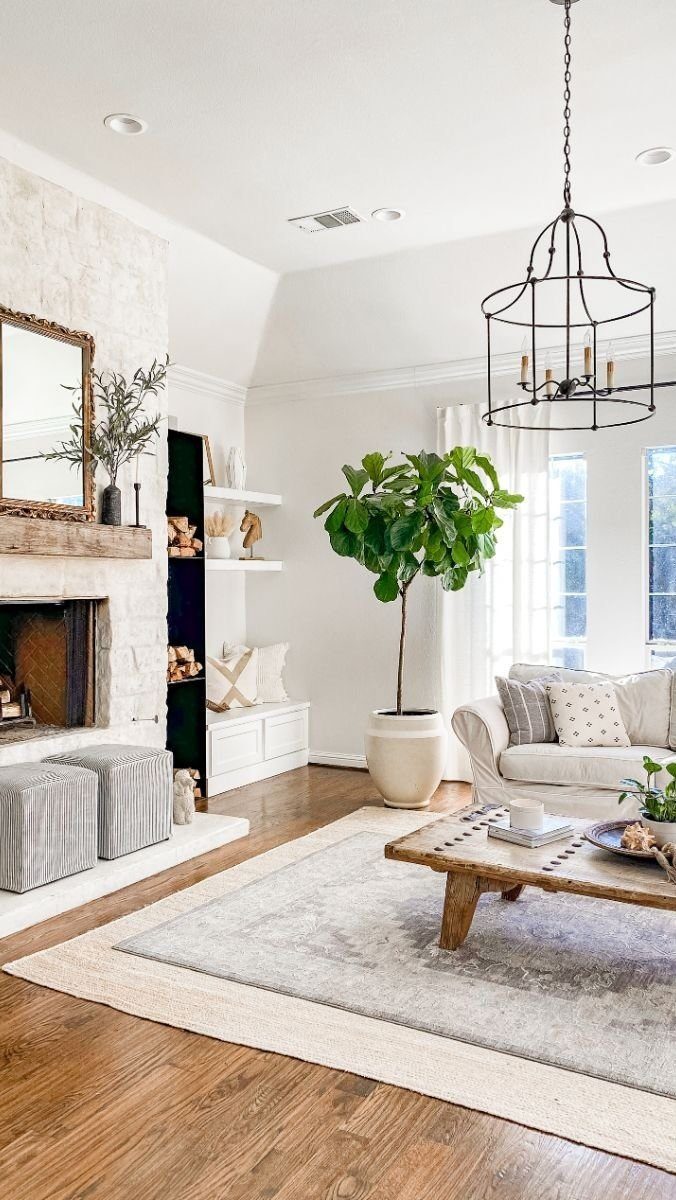 Grey rug layered over a larger cream rug in a bright living room