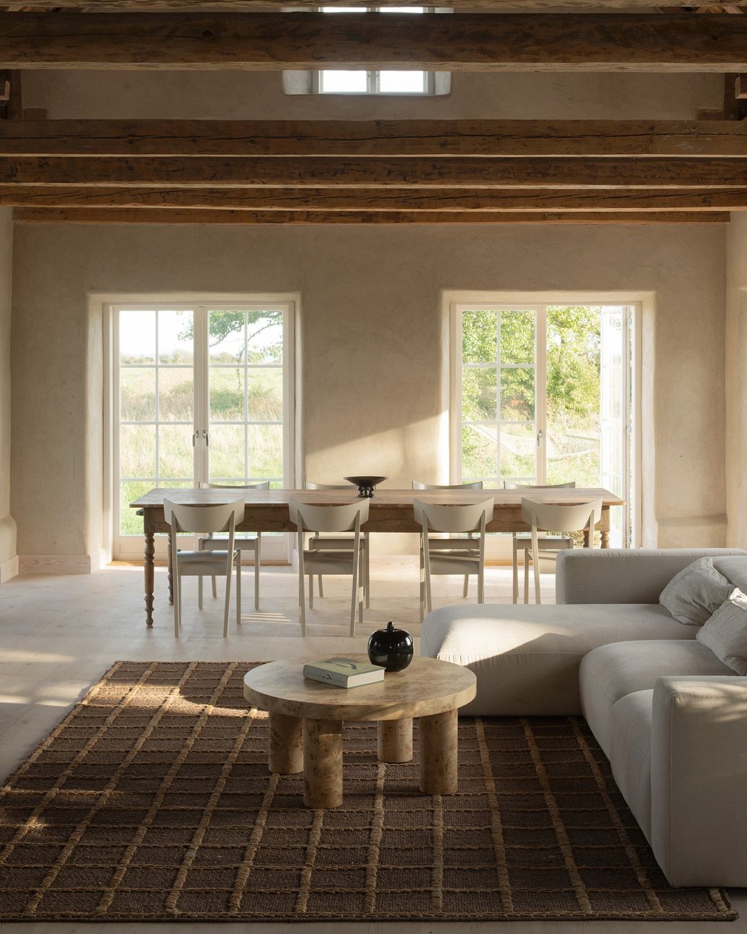 Brown woven jute rug under a wooden coffee table in a rustic living room.