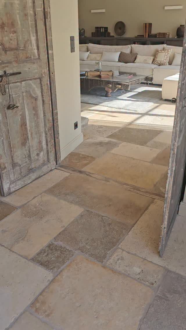Natural stone floor tiles in beige and tan leading into a living room.