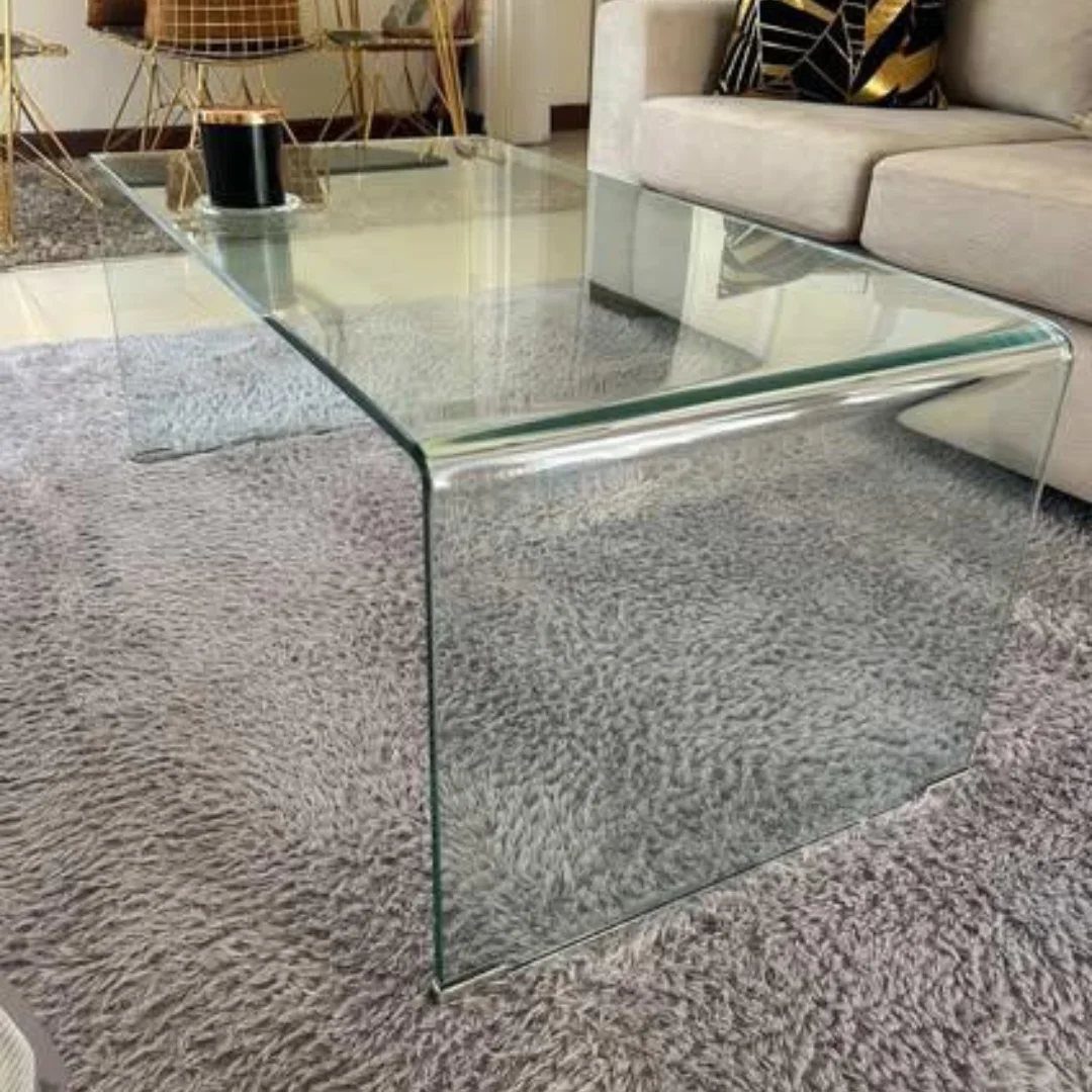 Glass rectangular coffee table on a grey shag rug beside a beige sectional sofa.