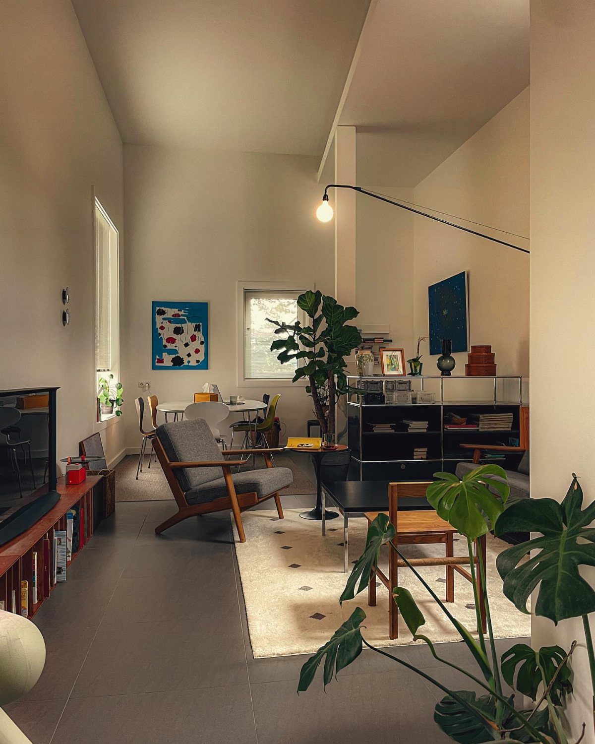 Cream rug covering grey floors in a small living room with modern furniture.