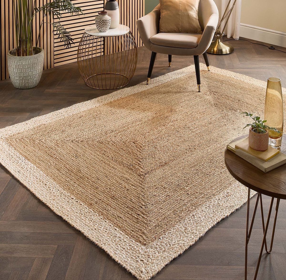 Woven jute area rug with geometric pattern on dark herringbone wood flooring