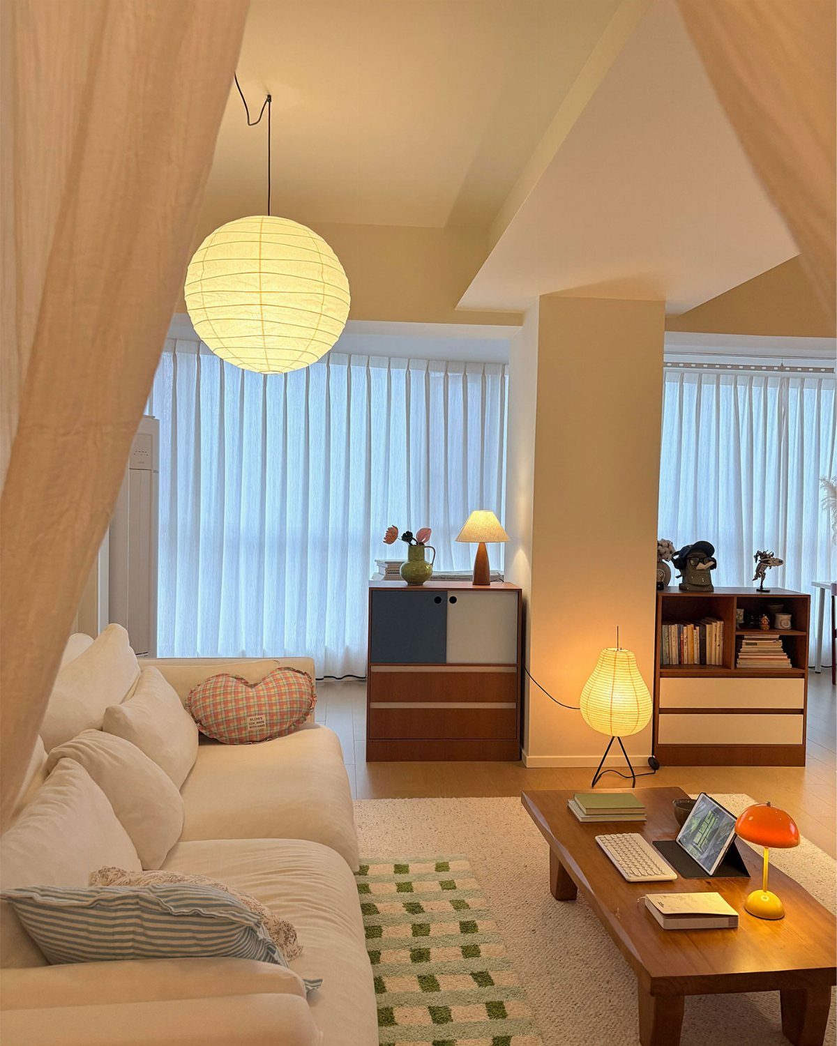 Cozy living room featuring a spherical pendant lamp, floor lamp, and table lamps.