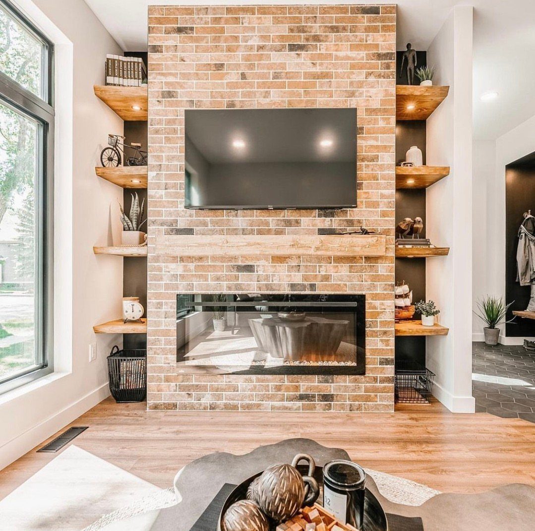 Electric fireplace built into a brick wall with a mounted TV and floating shelves.