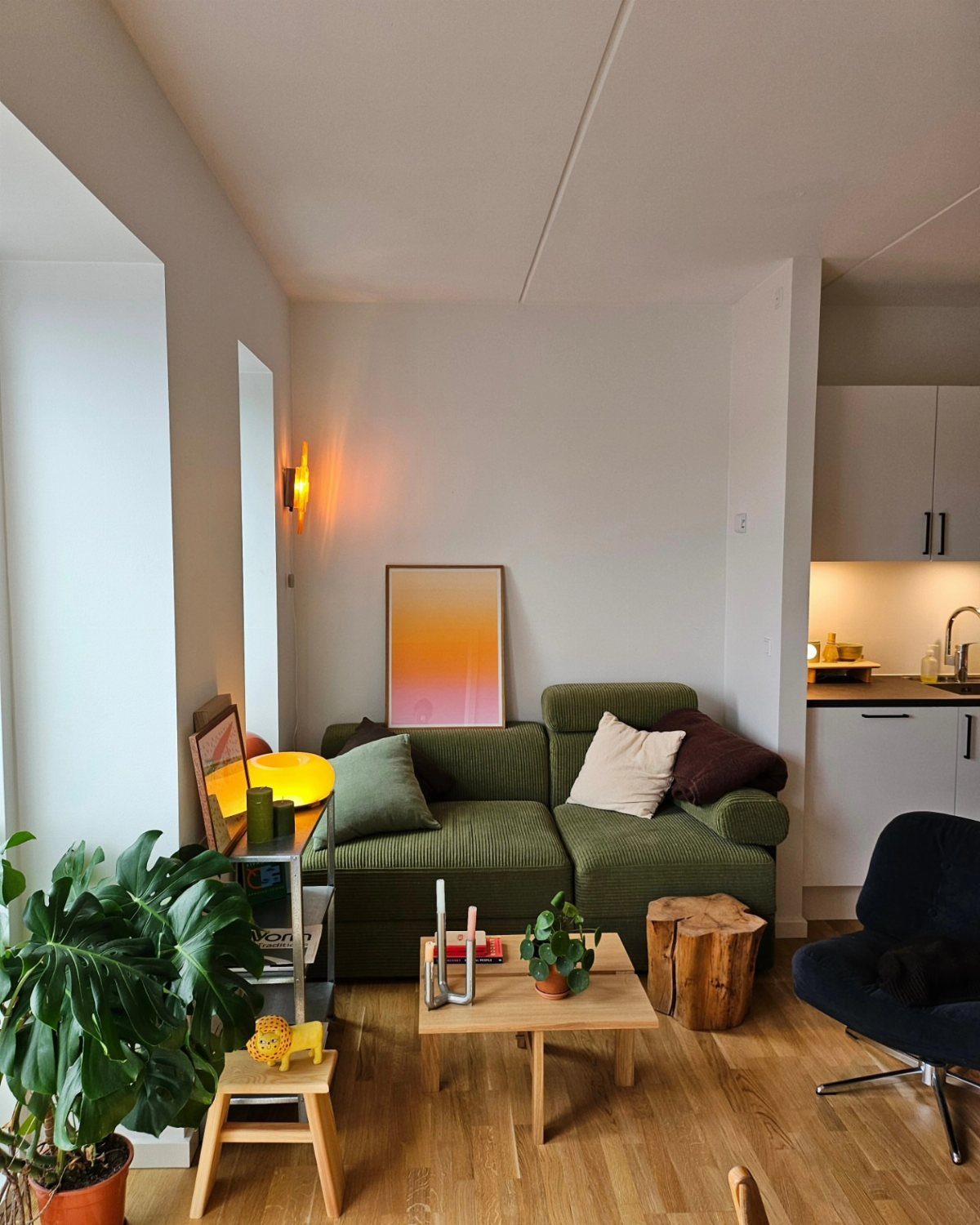Green sofa and wooden coffee table in a small, brightly lit living room.