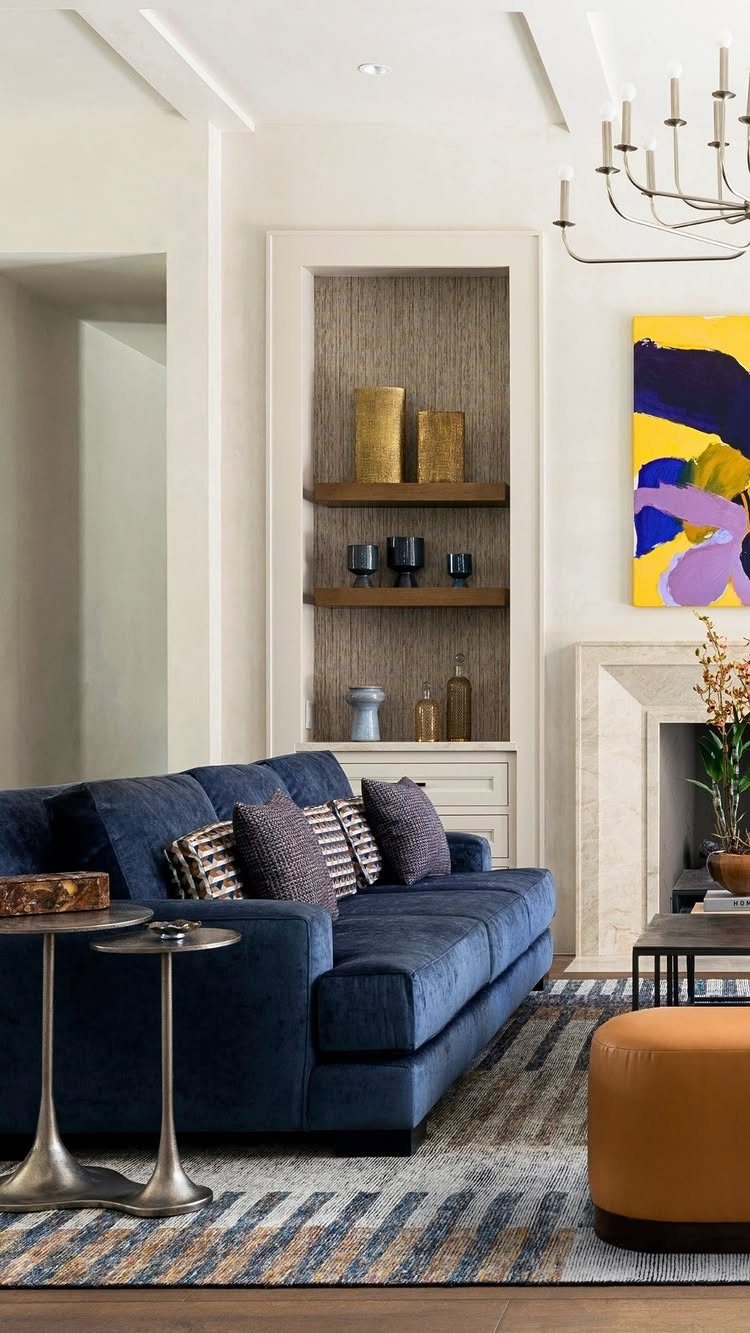 Navy blue sofa and orange pouf on a striped rug in a living room