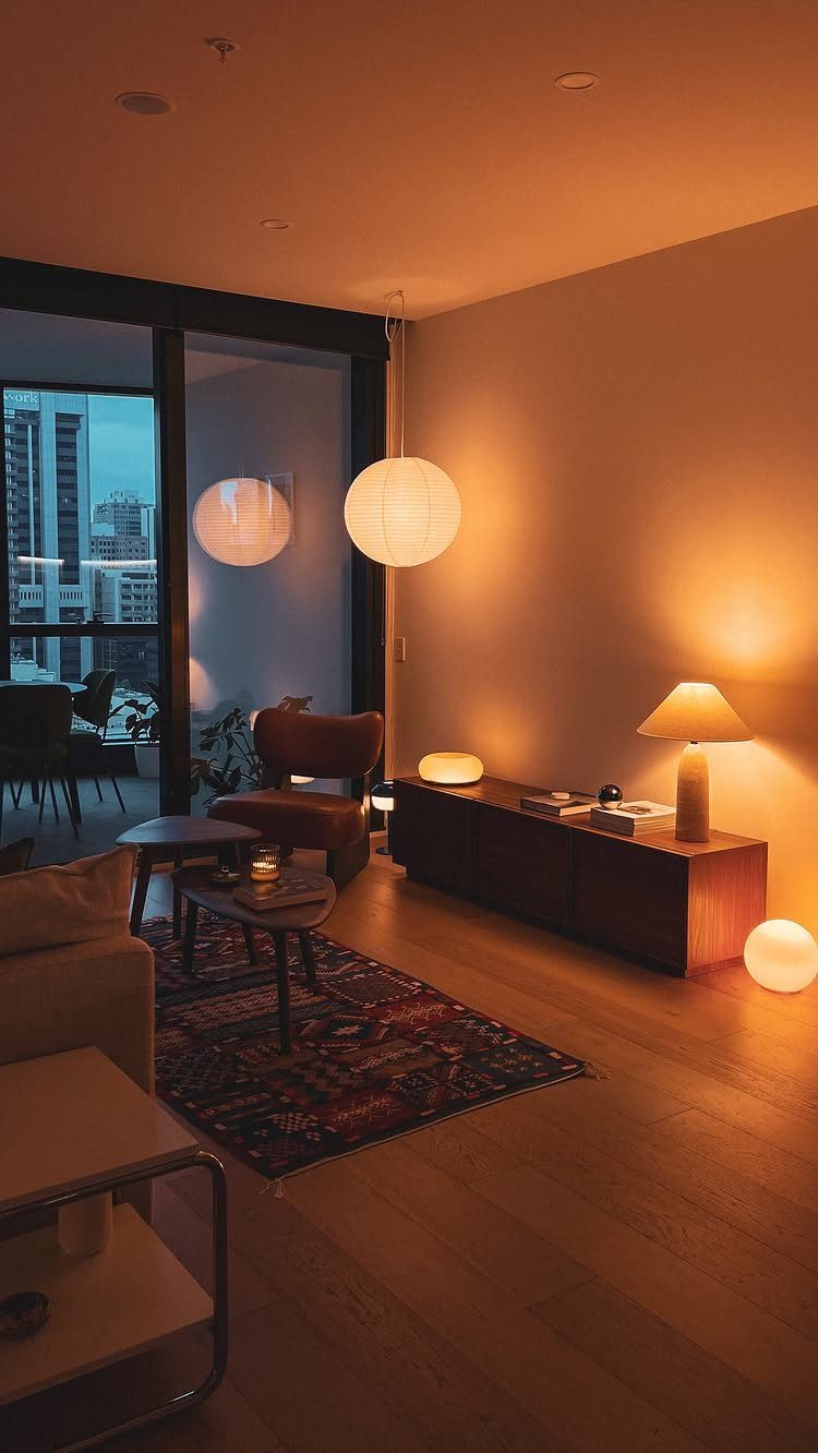 Living room with various warm light sources including a globe pendant and table lamp.