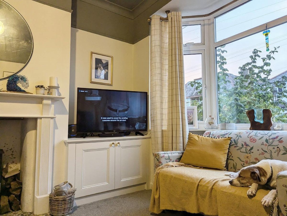 TV on a white cabinet tucked into a recessed wall alcove in a living room