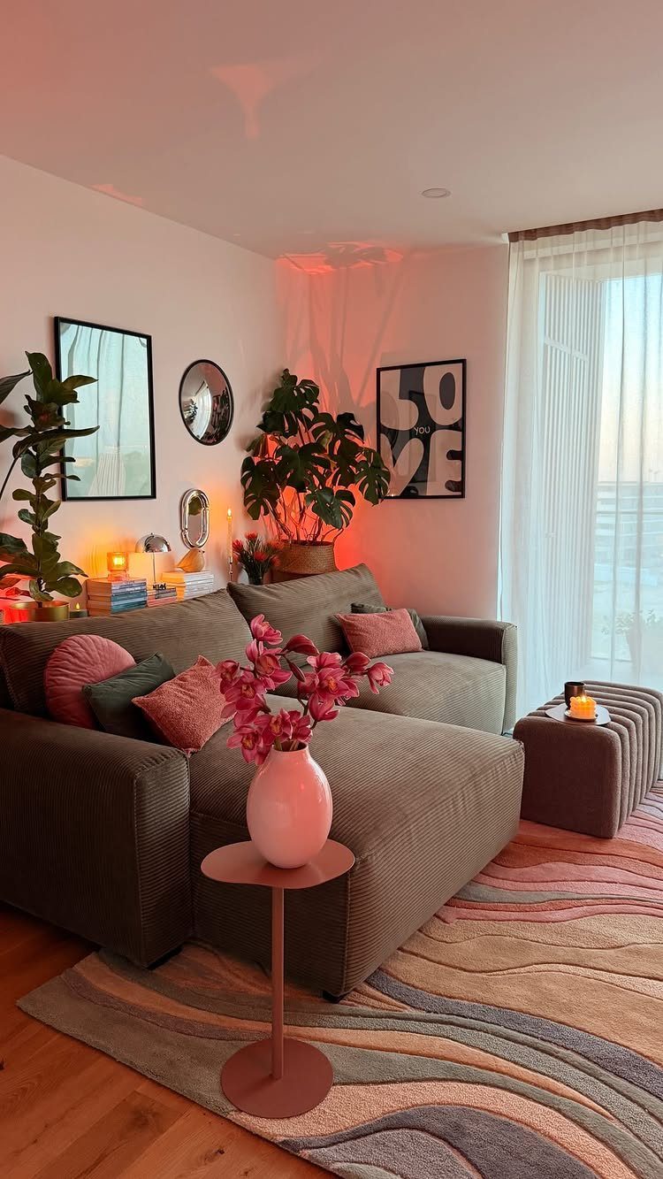 Potted indoor plant and artwork placed on a surface behind a grey sofa.