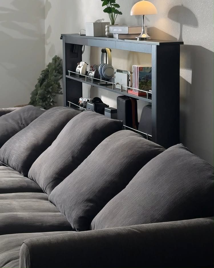 Dark grey sofa with a black console table and lamp behind it.