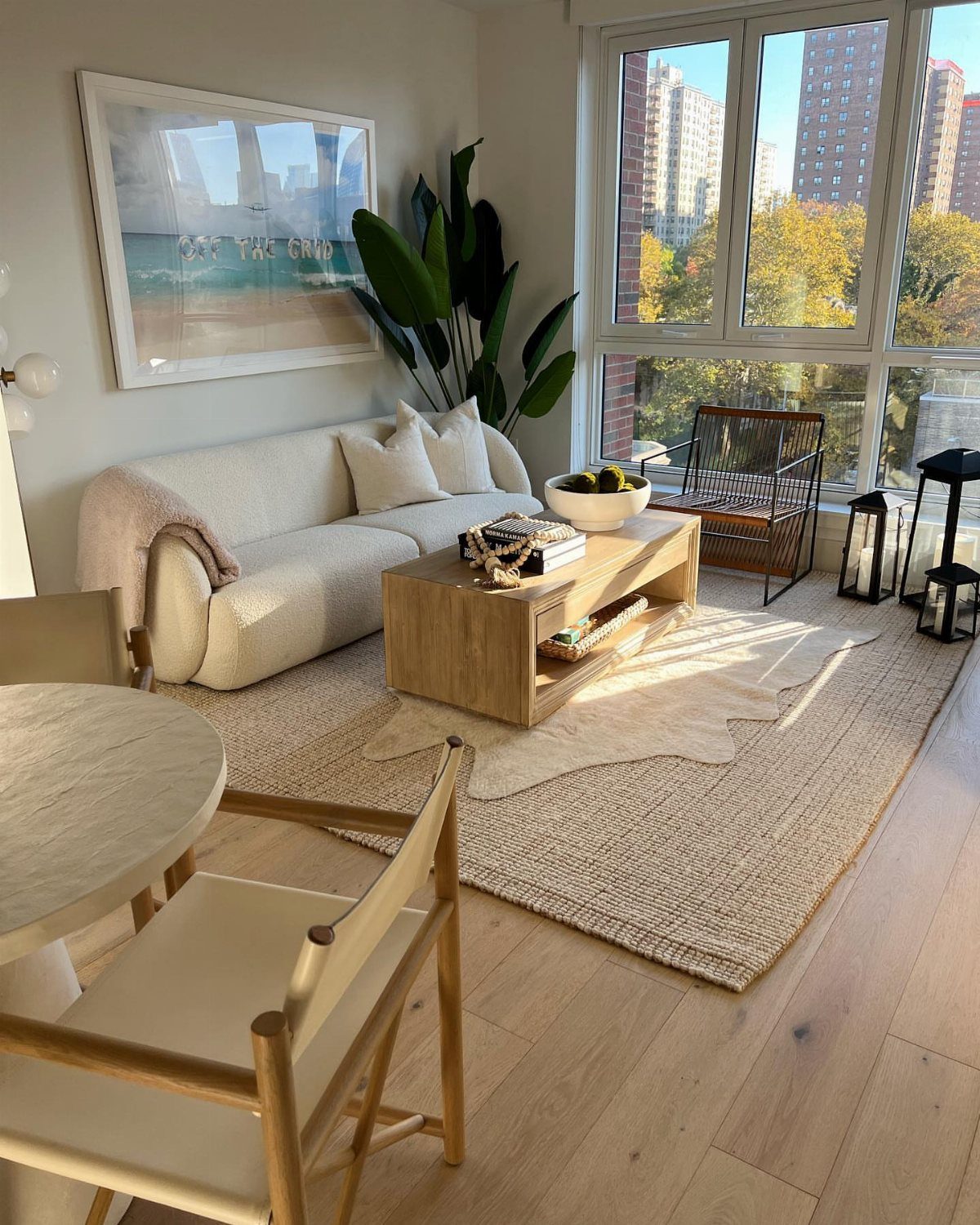 White sofa, wooden coffee table, and accent chair arranged on a layered rug.