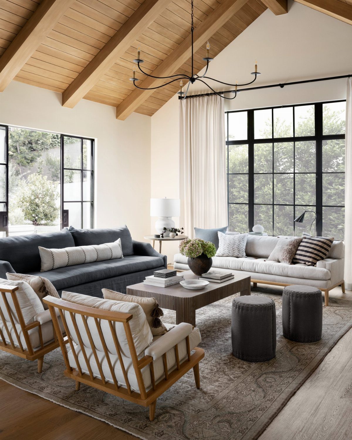 Two different sofas, one dark grey and one beige, in a bright living room.