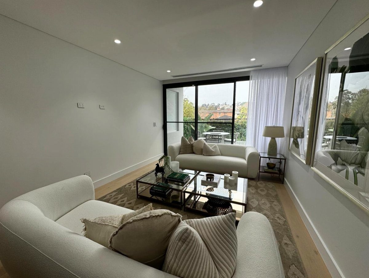 Two large framed art pieces hanging on a white wall in a modern living room