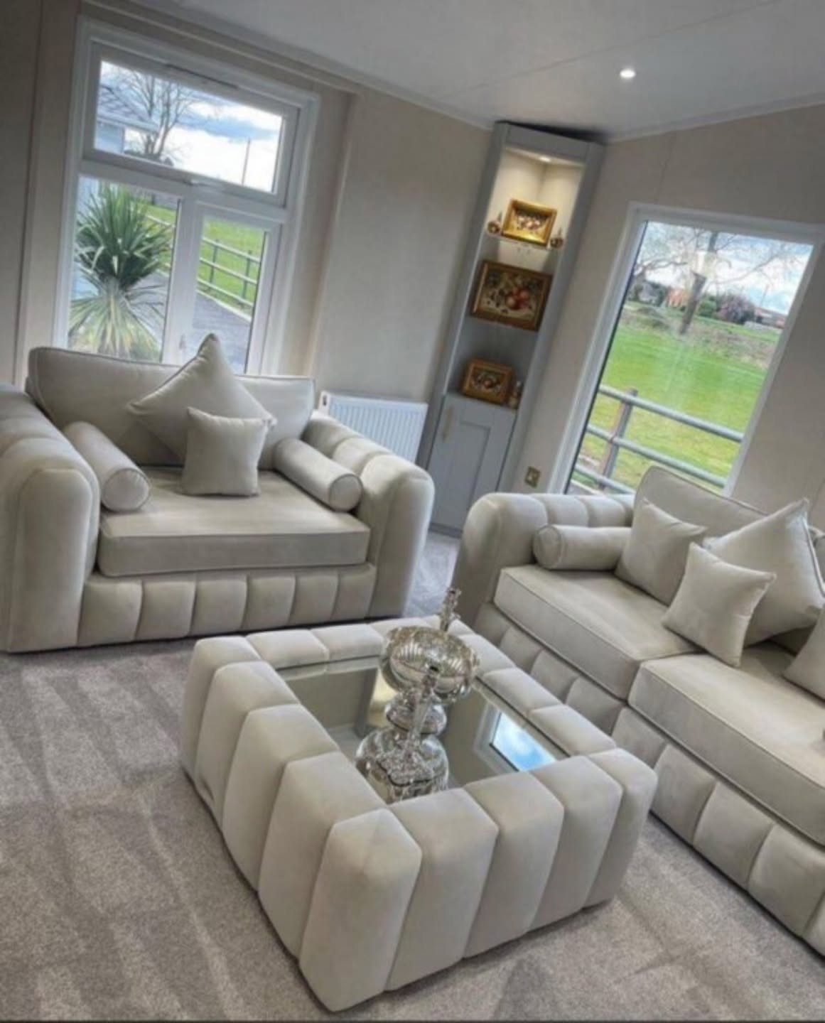 Two white sofas and a matching coffee table in a bright living room.
