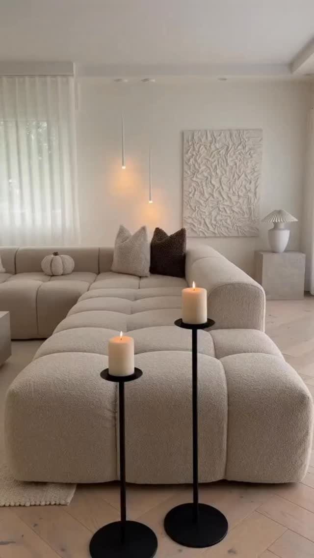 Modular white textured sofa in a minimalist living room with lit candles
