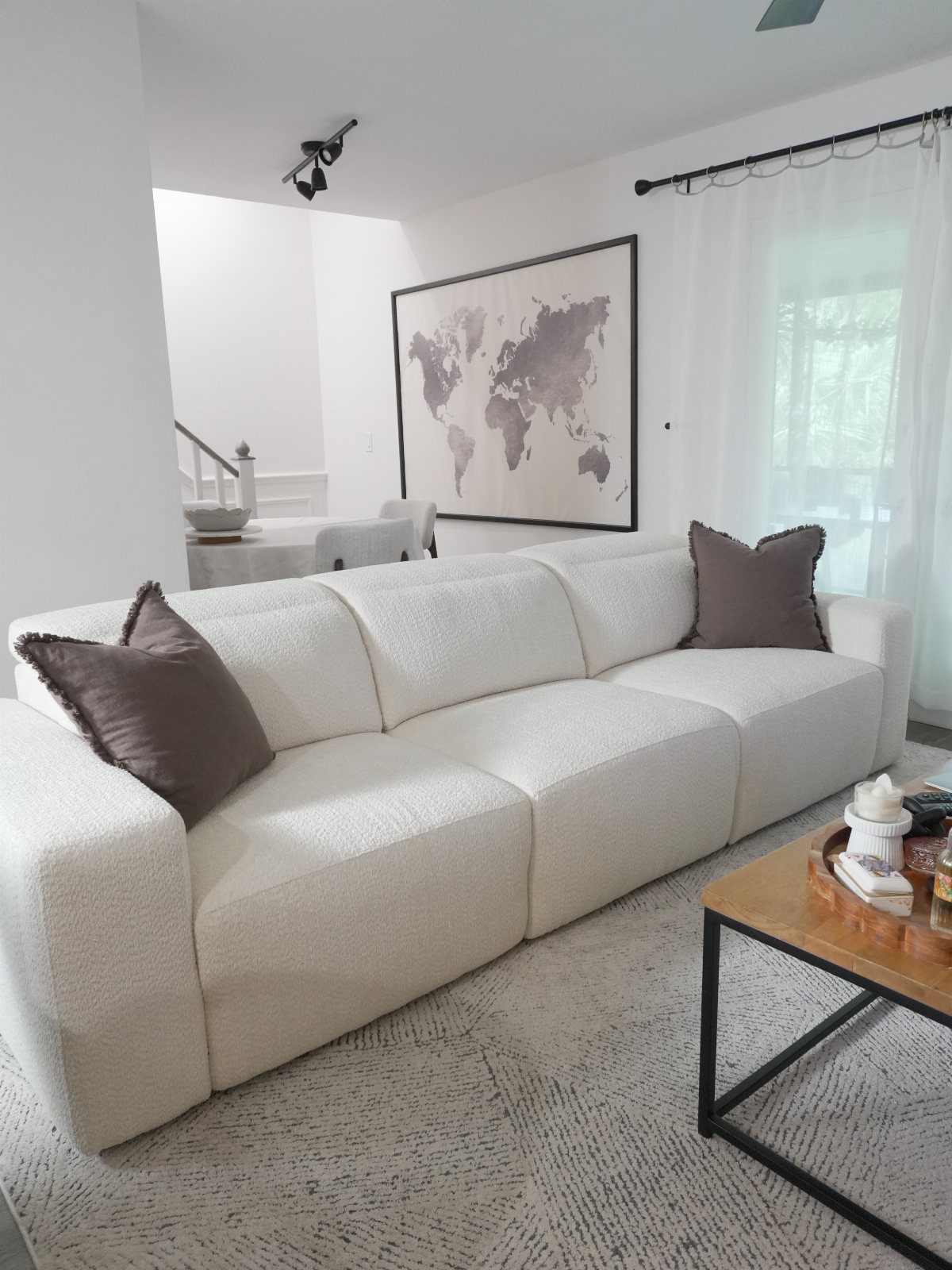 Textured white sofa with brown pillows in a bright, modern living room setting