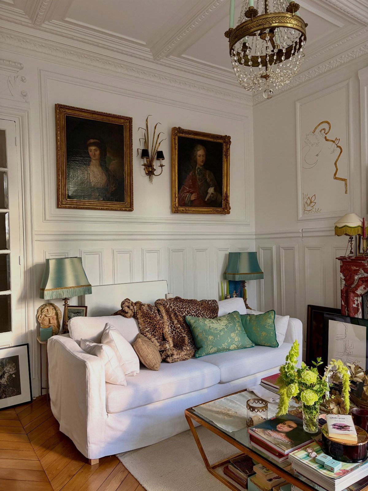 White sofa with teal and leopard print pillows in a classic living room